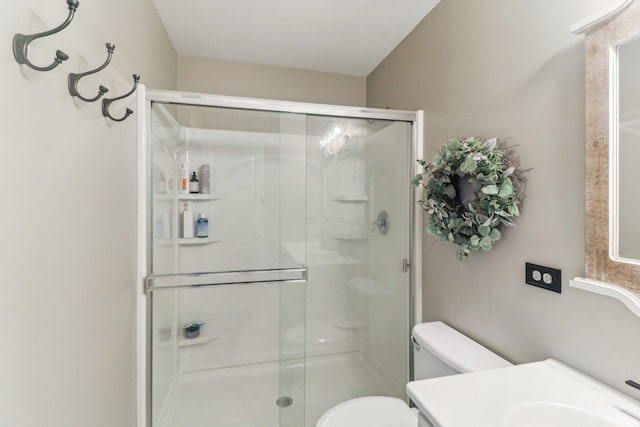 full bath featuring a stall shower, vanity, and toilet