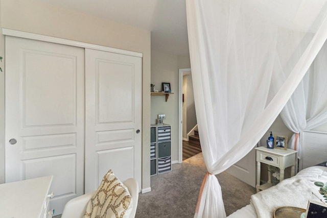 carpeted bedroom with a closet and baseboards