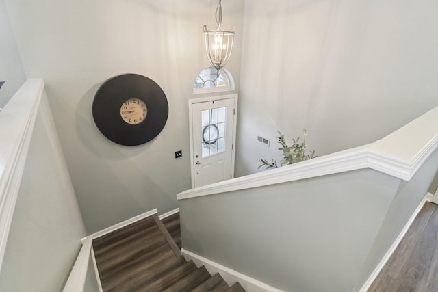 stairs with visible vents, baseboards, a chandelier, and wood finished floors