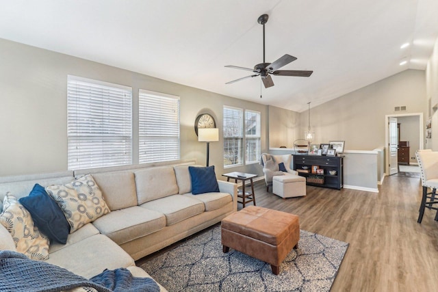 living area featuring baseboards, visible vents, a ceiling fan, wood finished floors, and vaulted ceiling