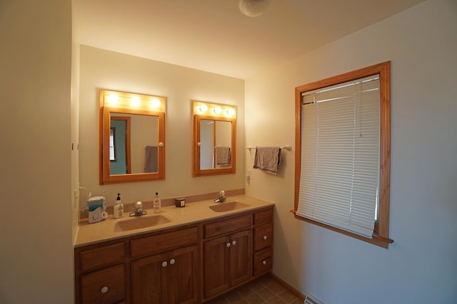 bathroom featuring double vanity, a sink, and baseboards