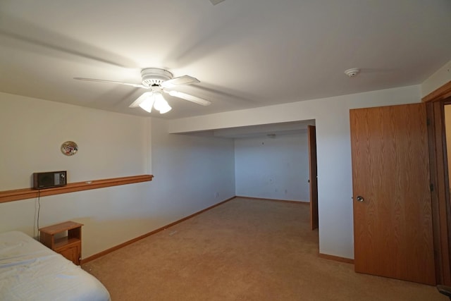 bedroom with a ceiling fan, light colored carpet, and baseboards