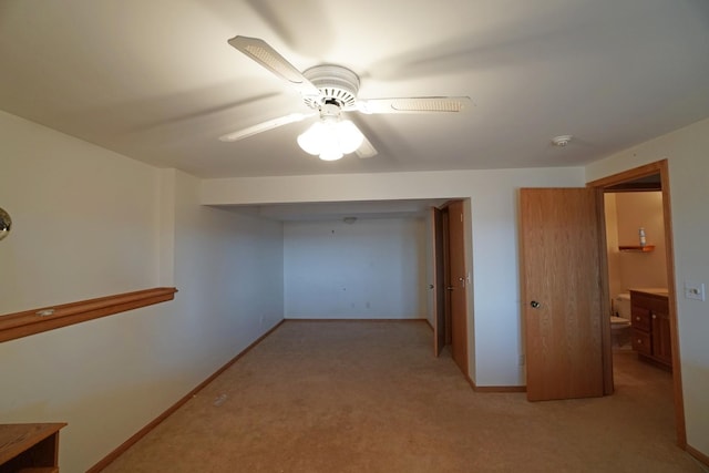 corridor featuring baseboards and light colored carpet