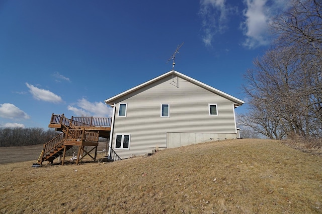 view of home's exterior with a yard, stairway, and a wooden deck