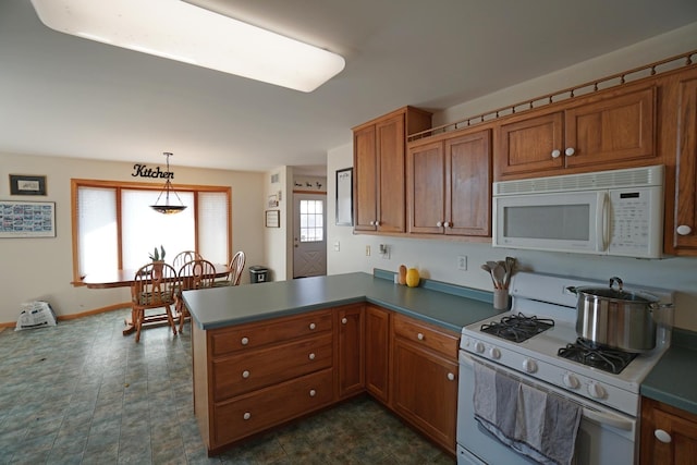 kitchen with a peninsula, white appliances, baseboards, brown cabinets, and pendant lighting