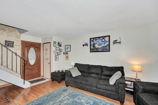 living area with stairway and wood finished floors