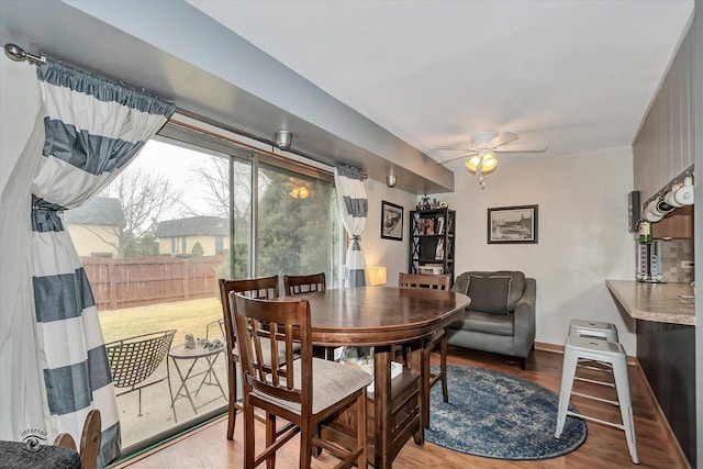 dining room featuring baseboards, wood finished floors, and ceiling fan