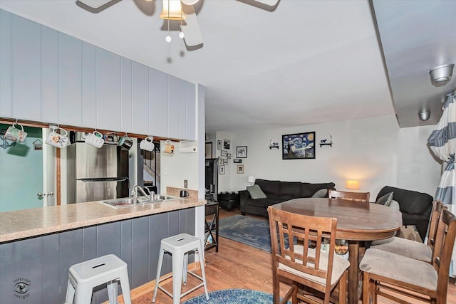 dining space with light wood-style flooring and a ceiling fan