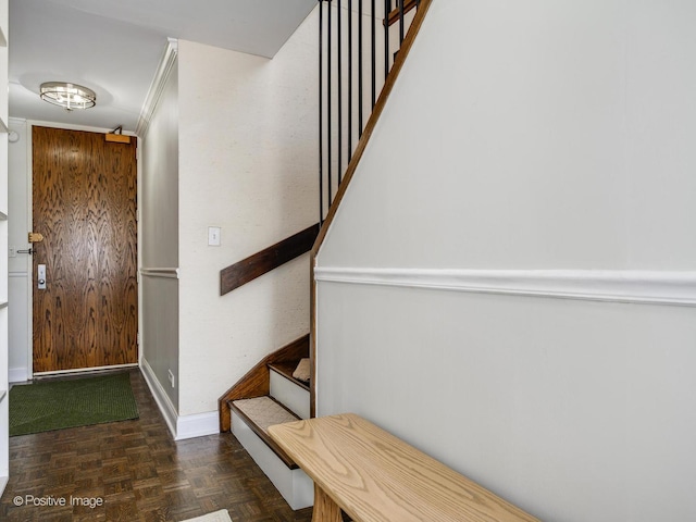 interior space featuring ornamental molding, baseboards, and stairs