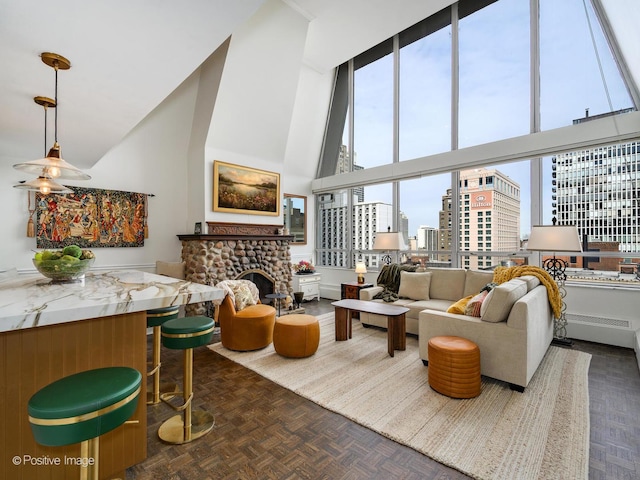 living room featuring a towering ceiling, a view of city, and a stone fireplace