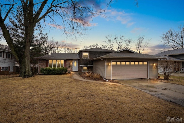 view of front facade featuring concrete driveway, a lawn, and an attached garage