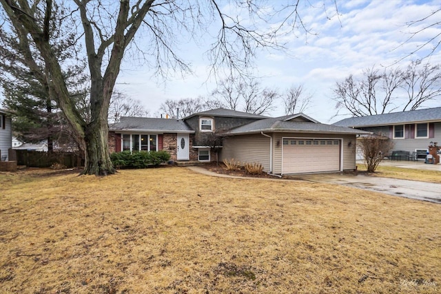 split level home with a garage, driveway, brick siding, and a front lawn