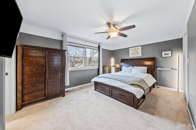 bedroom with a ceiling fan, light colored carpet, and baseboards