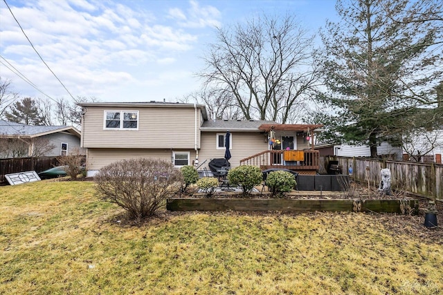 back of house with a deck, a yard, and fence