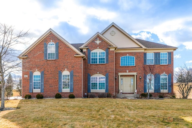 view of front of home featuring brick siding and a front yard