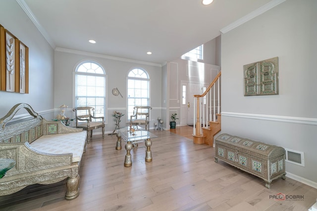 living area featuring stairs, wood finished floors, visible vents, and a healthy amount of sunlight