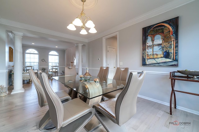 dining room with ornate columns, ornamental molding, a chandelier, light wood-type flooring, and baseboards