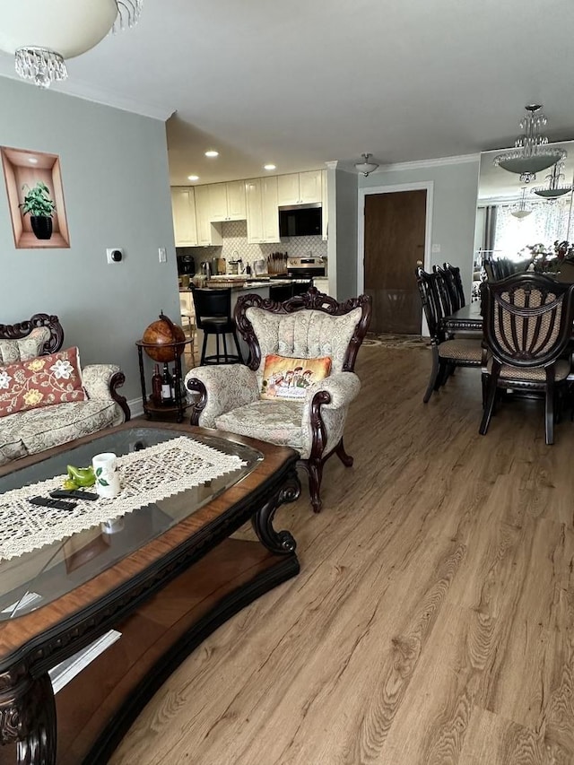 living area with crown molding and light wood-style flooring