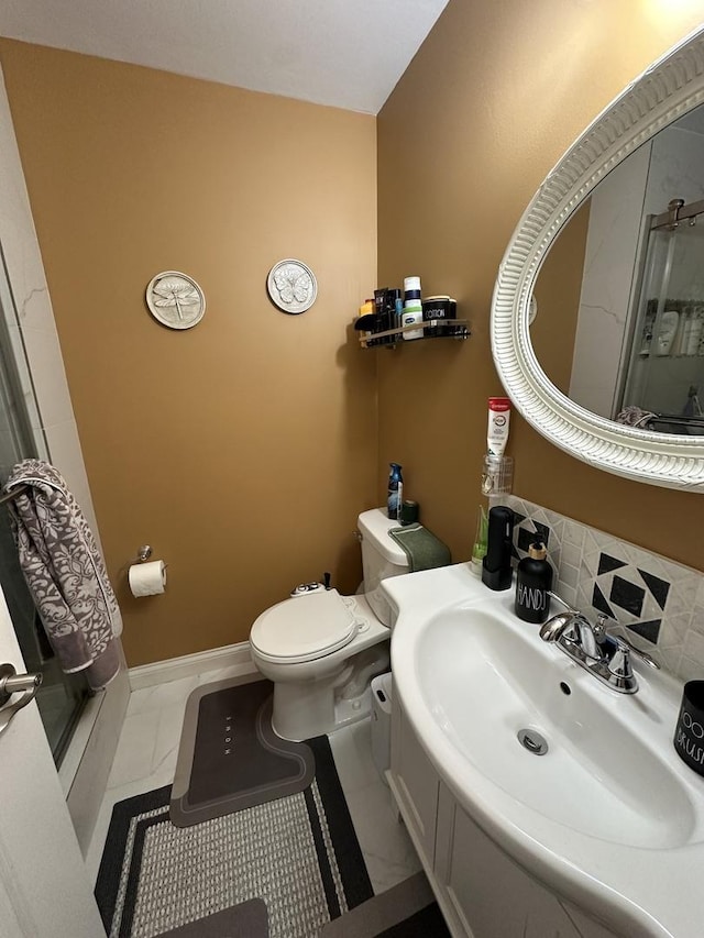 full bathroom featuring marble finish floor, a sink, toilet, and a shower stall