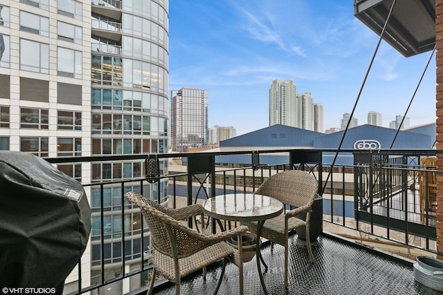 balcony with a view of city and grilling area