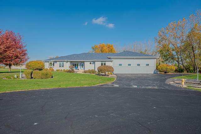 single story home featuring aphalt driveway and a front lawn