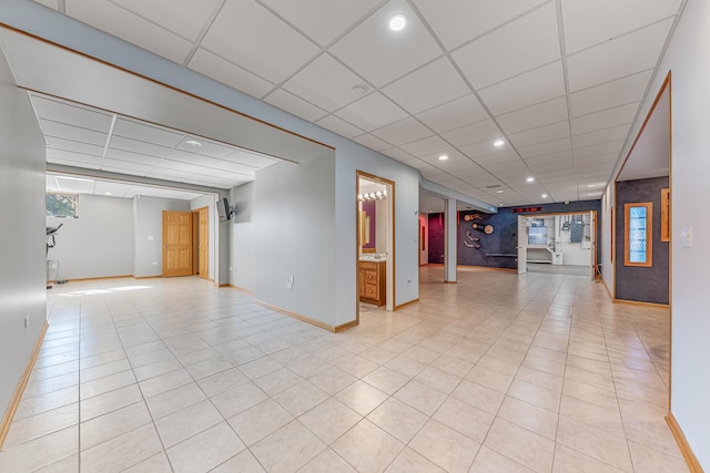 empty room featuring light tile patterned floors, recessed lighting, a drop ceiling, and baseboards