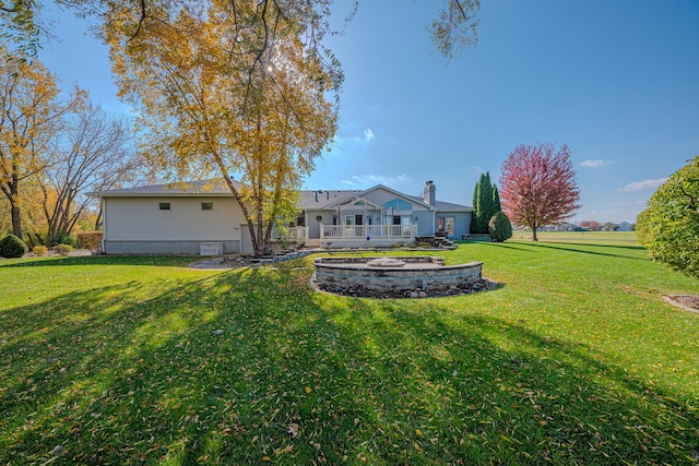 back of property with a deck and a lawn