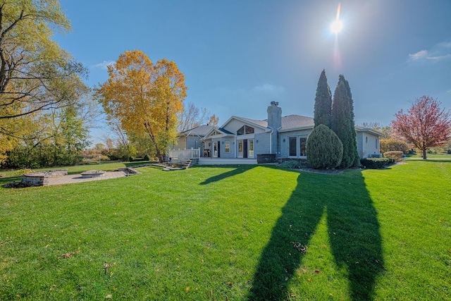 exterior space with a fire pit, a chimney, and a front yard