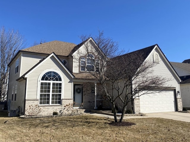 traditional-style home featuring brick siding, driveway, and an attached garage