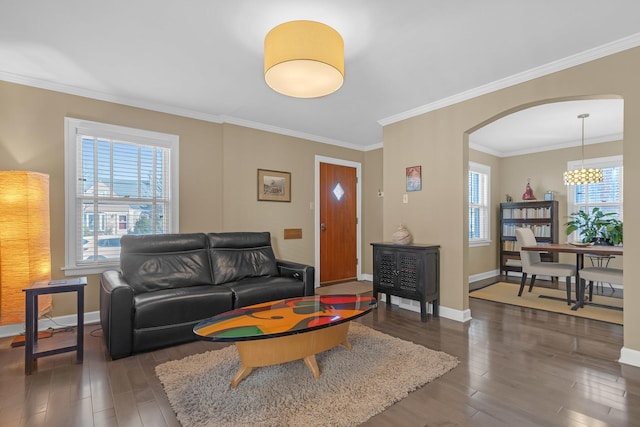 living area with arched walkways, plenty of natural light, dark wood-type flooring, and baseboards