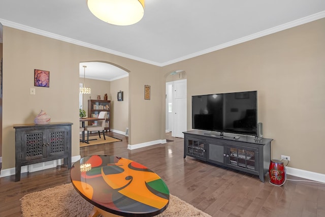 living area with baseboards, arched walkways, wood finished floors, and ornamental molding