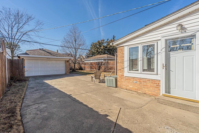 exterior space with an outbuilding, a detached garage, central AC, and fence