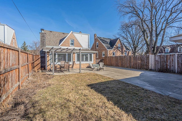 back of house with a patio area, a pergola, a fenced backyard, and a chimney