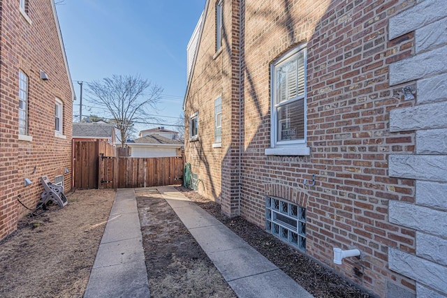 view of home's exterior featuring fence and brick siding