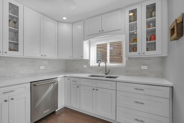 kitchen featuring a sink, backsplash, stainless steel dishwasher, white cabinetry, and light countertops