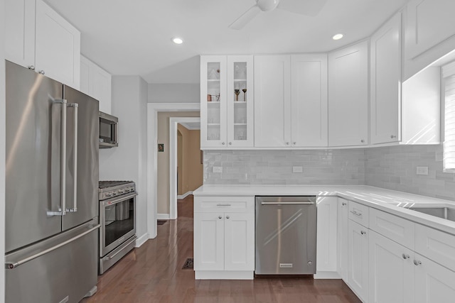 kitchen with light countertops, white cabinets, glass insert cabinets, and stainless steel appliances