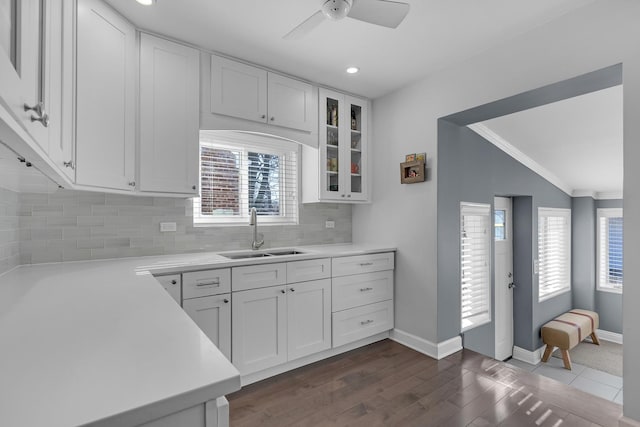 kitchen with a sink, glass insert cabinets, lofted ceiling, and white cabinets