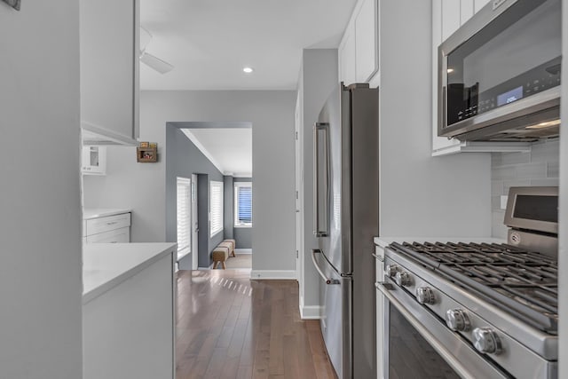 kitchen featuring tasteful backsplash, dark wood-style floors, white cabinetry, appliances with stainless steel finishes, and light countertops