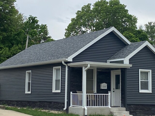 225 W Dakota St, Spring Valley, IL 61362 - view of front facade with covered porch, roof with shingles, and stone siding