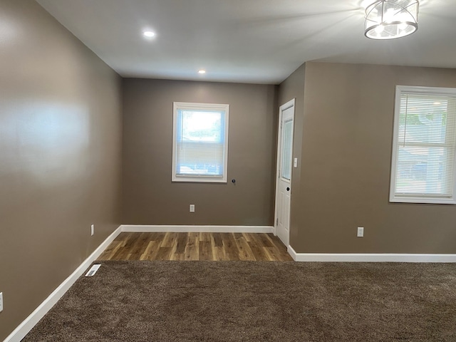 225 W Dakota St, Spring Valley, IL 61362 - carpeted empty room featuring plenty of natural light, recessed lighting, wood finished floors, and a chandelier
