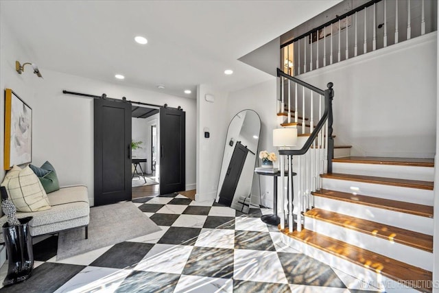 foyer entrance featuring recessed lighting, stairway, a barn door, baseboards, and tile patterned floors