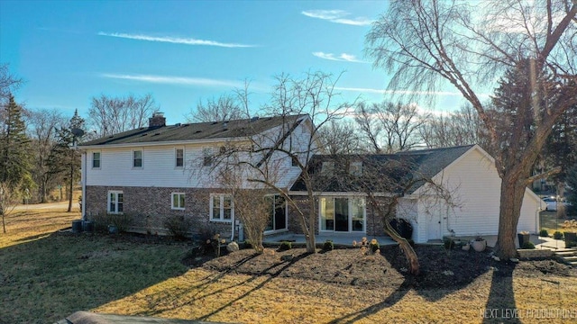 traditional-style house featuring a chimney and a front lawn