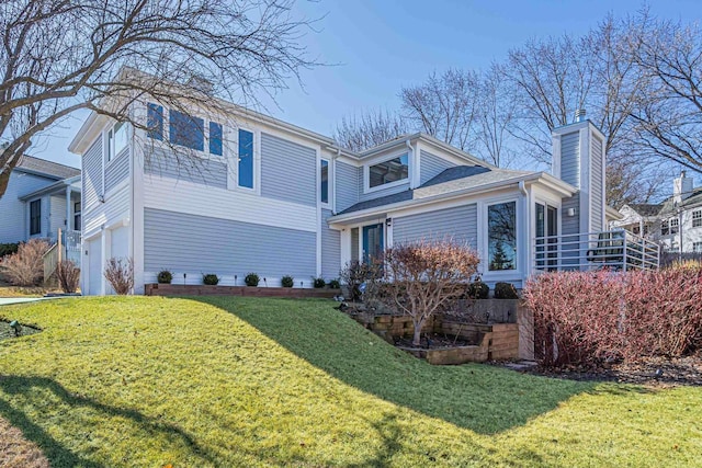 view of side of home featuring an attached garage, a chimney, and a yard