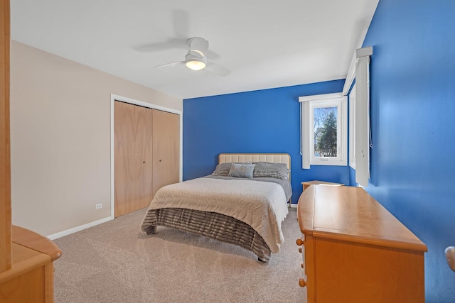 carpeted bedroom featuring a closet, baseboards, and ceiling fan