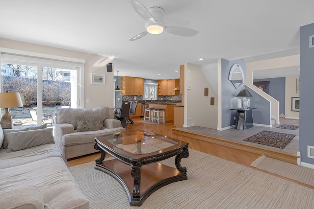 living room with light wood-type flooring, visible vents, recessed lighting, baseboards, and ceiling fan