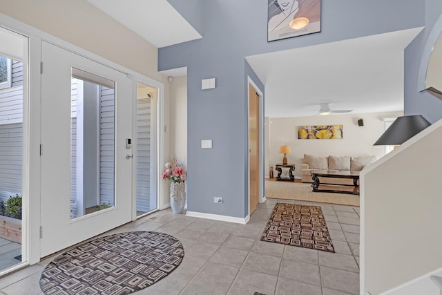 tiled foyer with baseboards and a ceiling fan