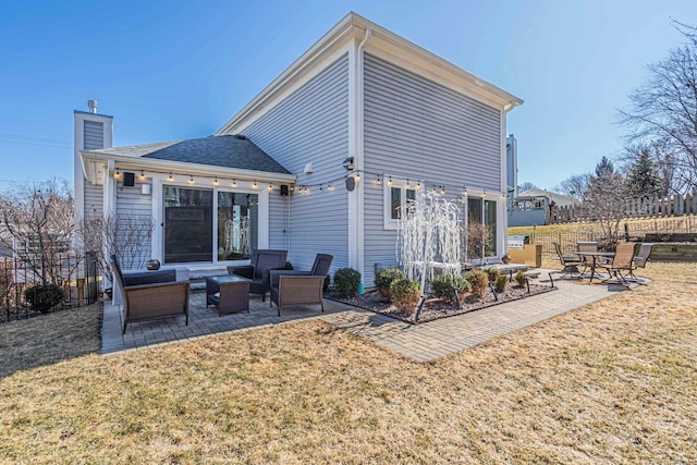 rear view of house with a patio area, a yard, and fence