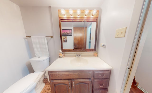 half bath featuring vanity and toilet