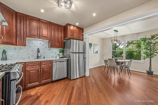 924 Colony Lake Dr, Schaumburg, IL 60194 - kitchen featuring stainless steel appliances, light countertops, a chandelier, backsplash, and wood finished floors
