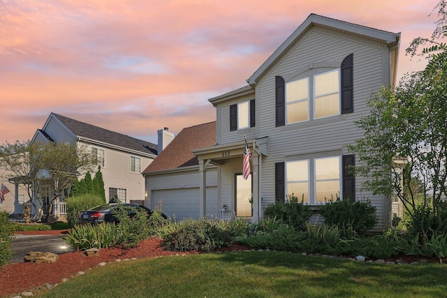 view of front of home with an attached garage and a front lawn